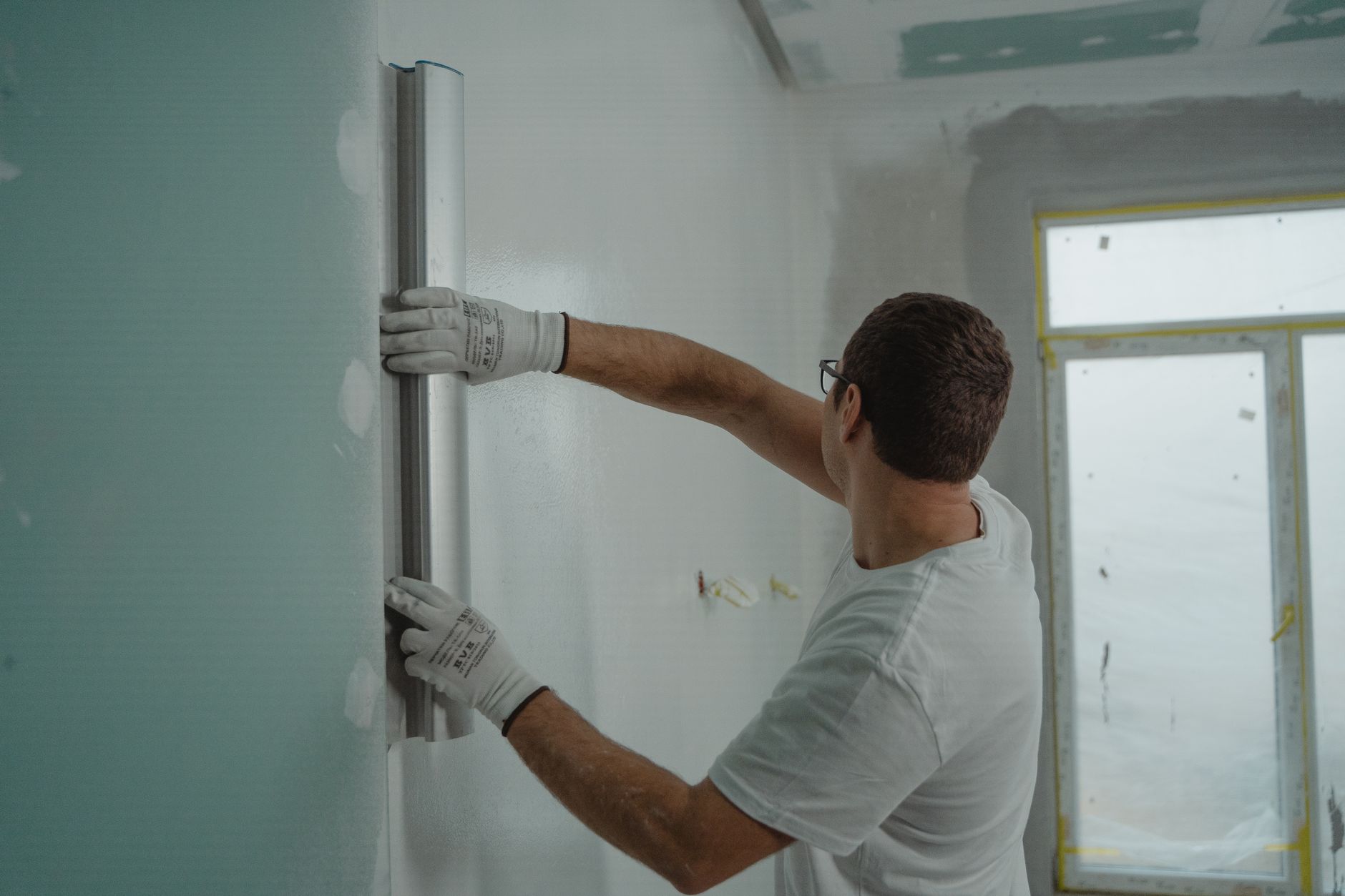 A fitter skimming a wall on a real job